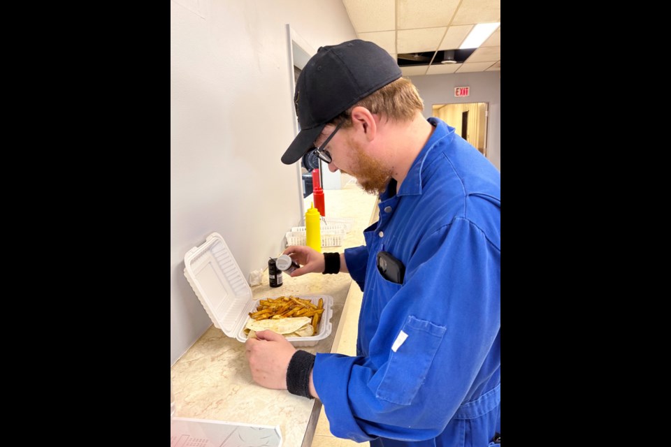 A customer adds the final touch to a wrap and fries