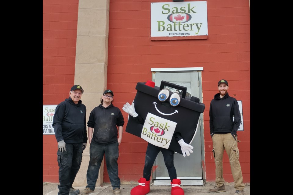 Kevin Whelan (left), Kane Morin, "Volts," and manager Dylan Kirton (right) stand outside the entrance to SaskBattery Moose Jaw on April 10.