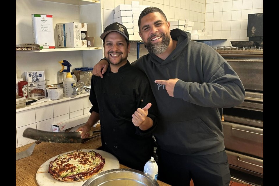 Roughriders head coach Corey Mace, right, poses for a photo with the head cook at The Mad Greek restaurant during an earlier visit to Moose Jaw.