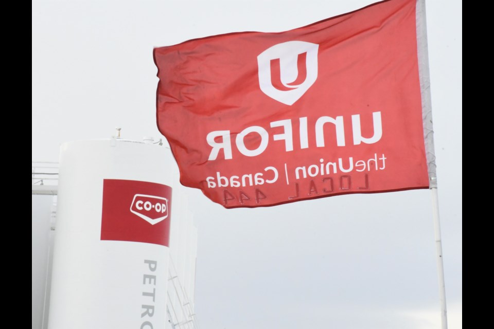 A Unifor flag flies from a fence that blocks the Co-op's bulk fuel terminal, which stands in the background. Photo by Jason G. Antonio