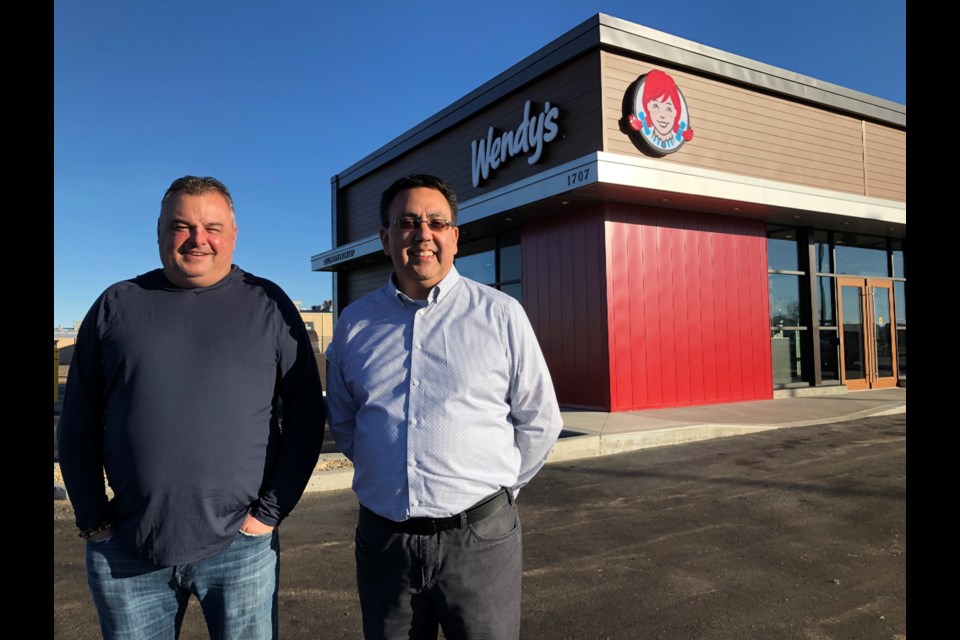 Darren Miller, owner of the new Wendy's, and Scott White, director of operations in Saskatchewan, stand in front of the new business during its grand opening. Photo by Jason G. Antonio