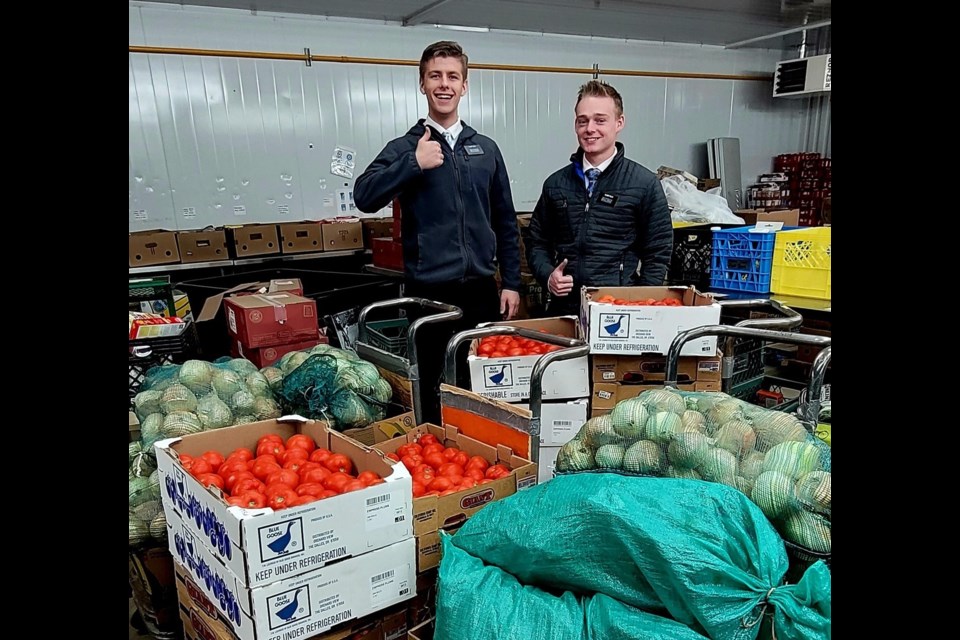 Two Mormon volunteers help with a 1,039 pound donation of fresh produce on Oct. 19. 