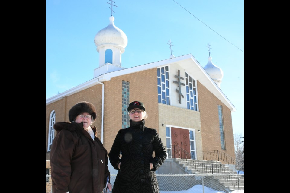 Jean Tkatch and Amy Jane Lunov pose outside St. Vladimir's Ukrainian Orthodox Church on South Hill. After nearly seven decades, the church shut down in late 2021 due to few members and rising costs. Photo by Jason G. Antonio 
