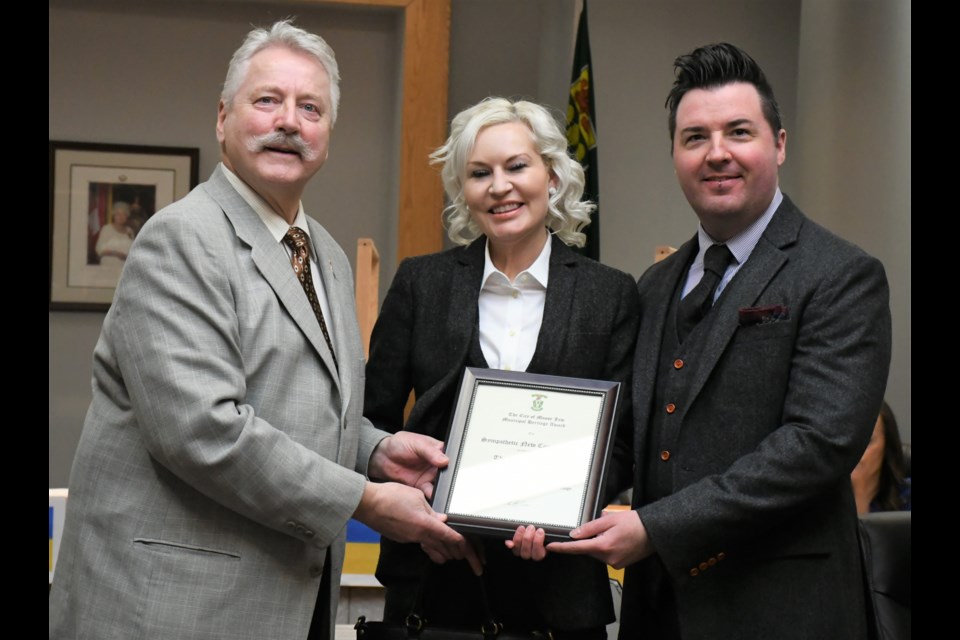 Mayor Clive Tolley (left) presents a heritage award to Jared and Alyssa Robinson during the March 14 council meeting. The Robinsons were recognized for respecting the heritage character of their property while redesigning their home. Photo by Jason G. Antonio 