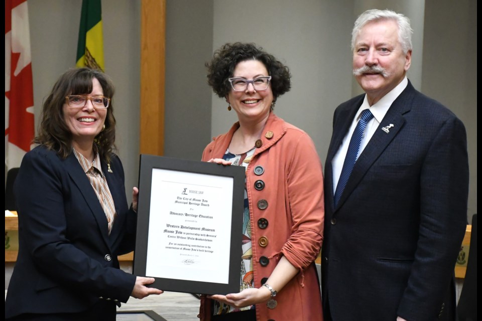 Coun. Crystal Froese, a council rep on the heritage advisory committee, and Mayor Clive Tolley present the advocacy and heritage education award to Karla Rasmussen with the Western Development Museum. Photo by Jason G. Antonio
