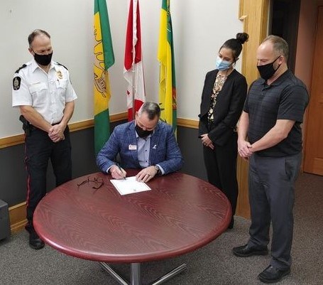 Deputy mayor Jamey Logan (seated) signs a document proclaiming Nov. 22 to 27 as National Addictions Awareness Week. Watching are police Supt. Devon Oleniuk (left), Gillian Froehlich (SHA Health Promotion, second from right) and Chad Topp (executive director, Thunder Creek Rehabilitation, right). Photo courtesy Mary Lee Booth. 