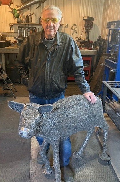 Metal artist Bill Keen poses with his baby bison sculpture, which has yet to be finished. Photo courtesy city hall