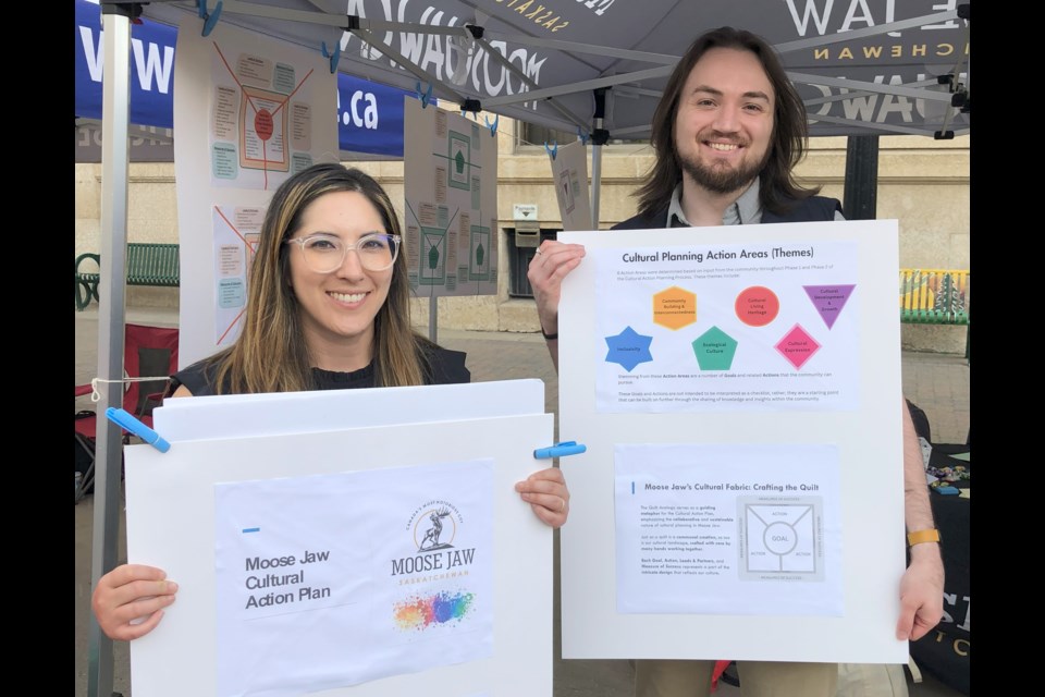 Prairie Wild Consulting's Samantha Mark (left), senior manager, and Hayden Austin, planning assistant, speak with residents at Sidewalk Days about the proposed cultural action plan. Photo by Jason G. Antonio 