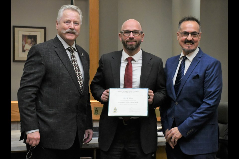 Derek Blais (centre) receives his leadership certificate from Mayor Clive Tolley (left) and city manager Jim Puffalt (right). Photo by Jason G. Antonio