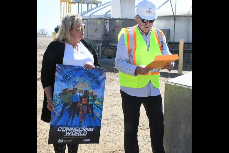 Staci Dobrescu, utilities supervisor of water and wastewater (left), listens to Mayor Clive Tolley proclaim May 21 to 27 as Public Works Week. Photo by Jason G. Antonio