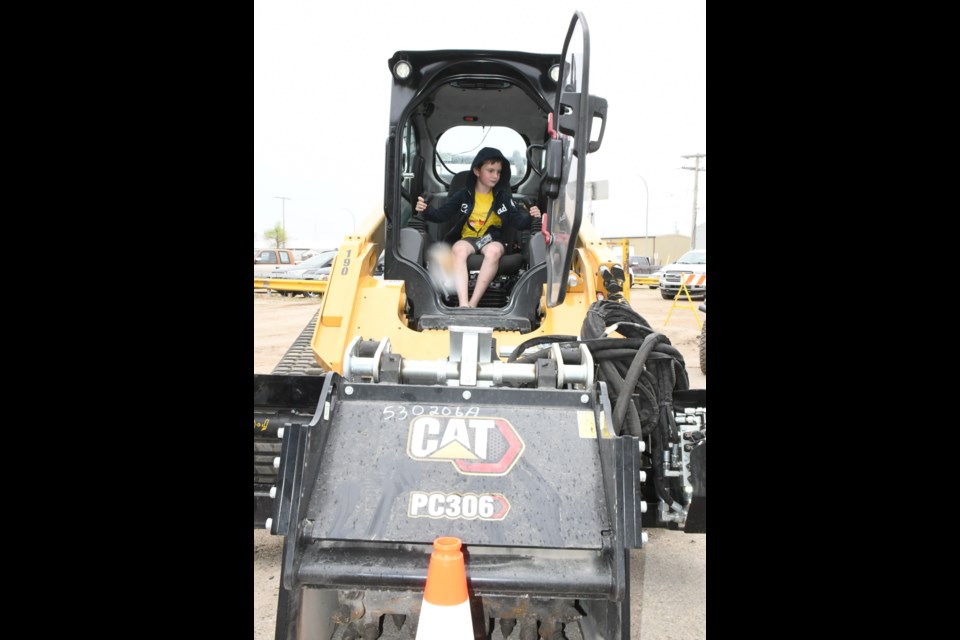 Asher M. from St. Michael School takes a seat inside a skid steer. Photo by Jason G. Antonio