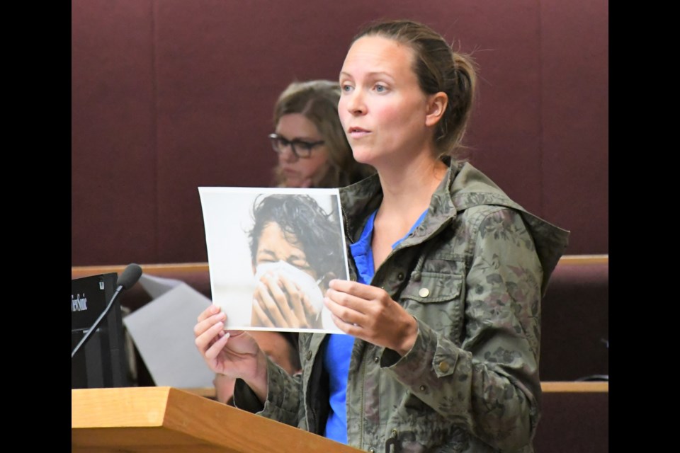 Using visual aids, resident Sarah Reich speaks against the use of mandatory masks, during a special council meeting on Aug. 31. Photo by Jason G. Antonio