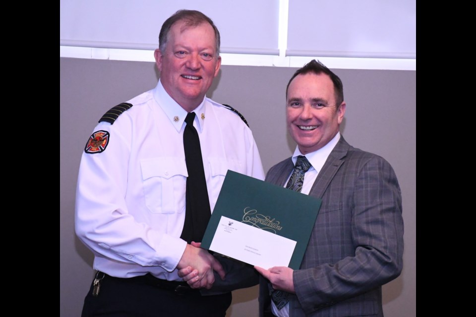 Fire Chief Rod Montgomery receives a certificate to honour his 30 years with the City of Moose Jaw from Mayor Fraser Tolmie. Photo by Jason G. Antonio