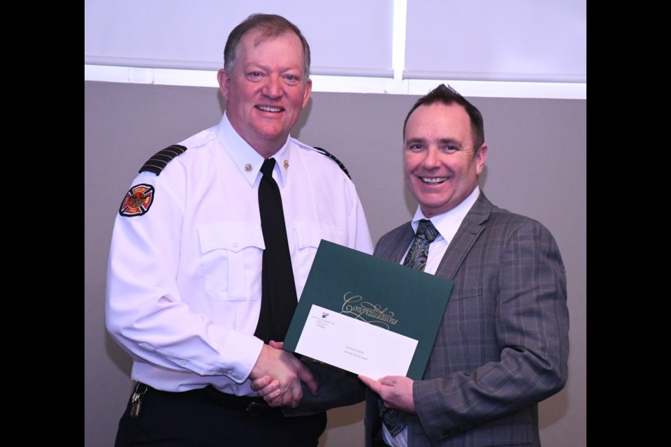 Fire Chief Rod Montgomery receives a certificate to honour his 30 years with the City of Moose Jaw from Mayor Fraser Tolmie. Photo by Jason G. Antonio