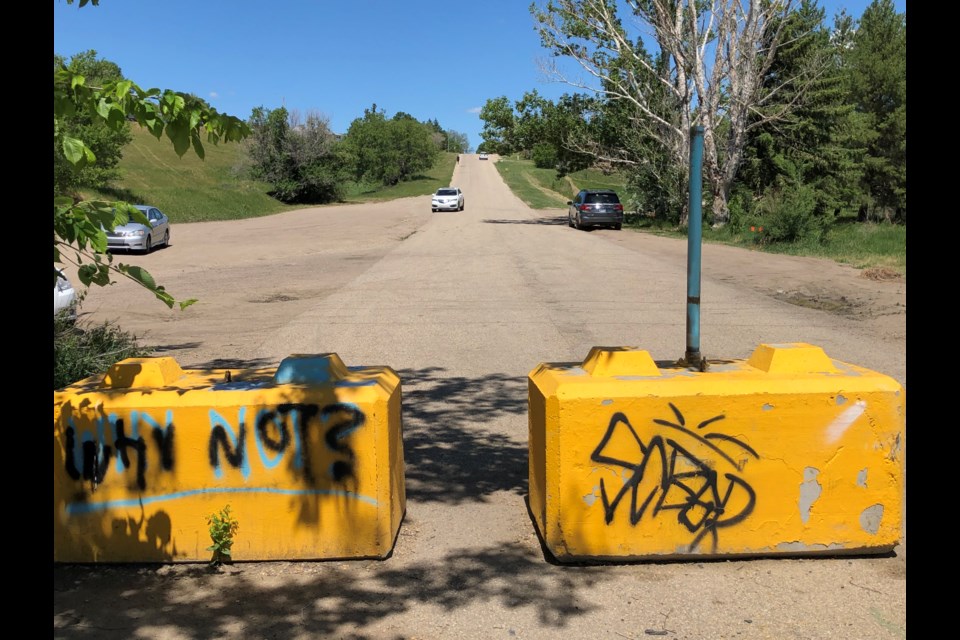 The Seventh Avenue Southwest road ends at the bottom of a hill, where barricades prevent vehicles from crossing the bridge that city hall closed in 2015. Photo by Jason G. Antonio 