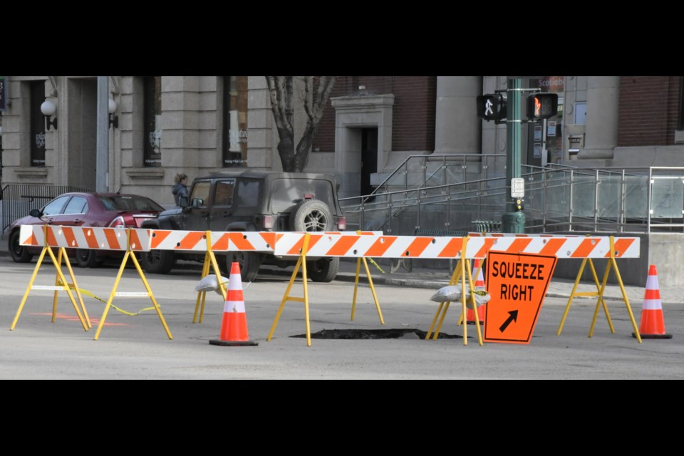 Signs direct motorists around a sinkhole that opened up at the intersection of Main Street and Fairford Street on March 8. Photo by Jason G. Antonio 