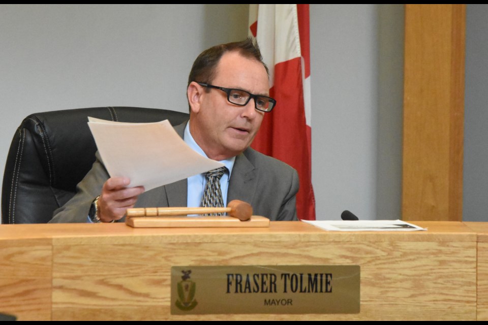 Mayor Fraser Tolmie holds up a report indicating Moose Jaw has low unemployment levels while talking about positive economic trends in the area during the Aug. 26 regular council meeting. Photo by Jason G. Antonio