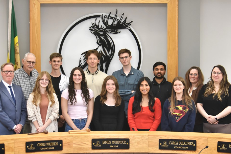 Members of the 2024 – 2025 Youth Advisory Committee gather for a group photo with Mayor James Murdock (far left) following their mock city council meeting on June 4 at Moose Jaw city hall.