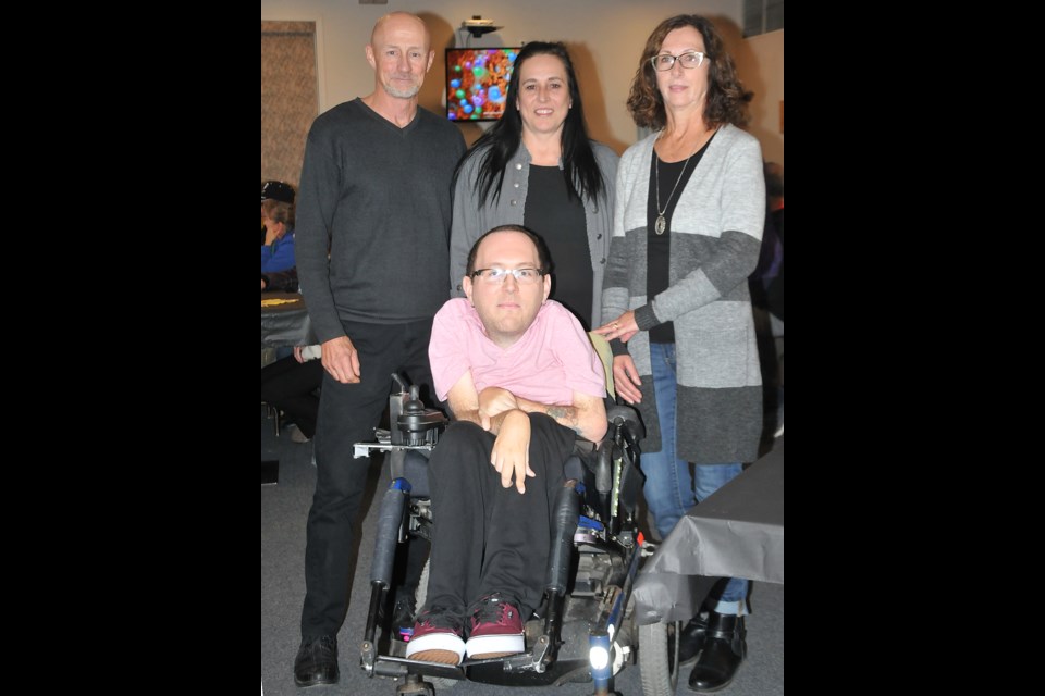Wayne Pringle (left), Karen Pringle (right) and Cole Pringle pause for a photo with Lynbrook Golf Club fundraiser organizer Lynn Perras-Selensky during the event last summer.