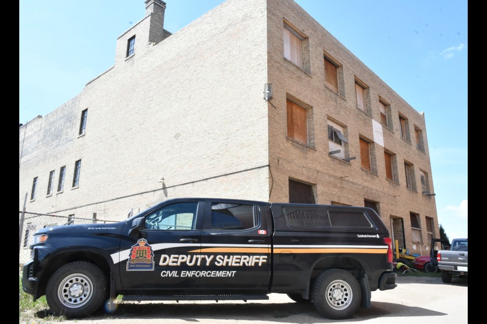 A deputy sheriff's truck sits in the alley behind the former Morrison Blackwood Hardware building. Photo by Jason G. Antonio