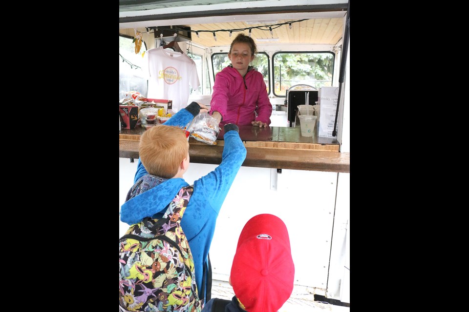 Cassidy Evans stuck through the rain and miserable weather to operate her now-famous lemonade stand outside of Palliser Heights School on Friday afternoon.