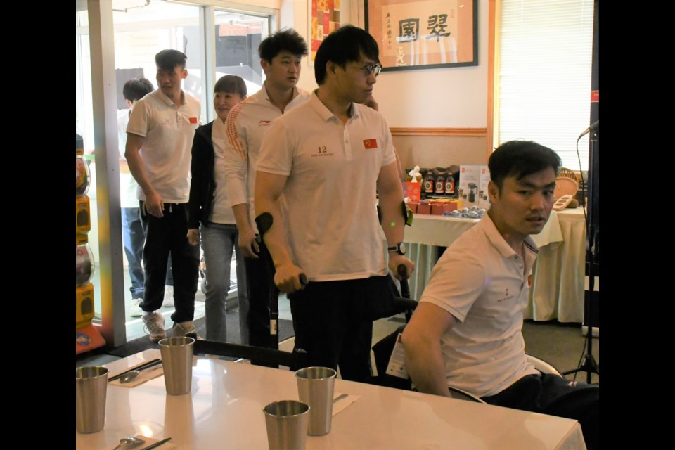 Members of China's sledge hockey team enter the restaurant to applause from the crowd. Photo by Jason G. Antonio