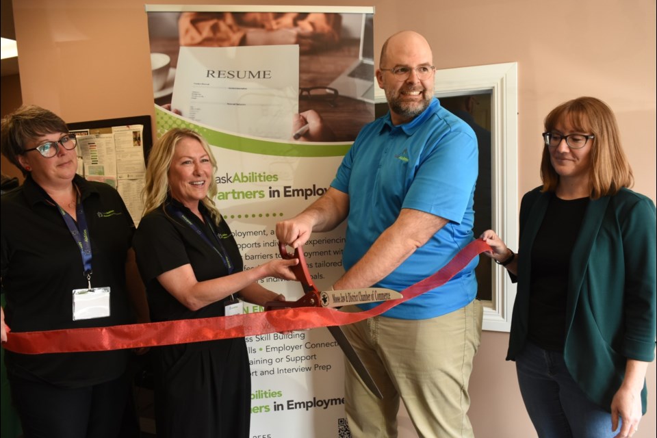 Participating in a ribbon cutting to celebrate 20 years of Partners in Employment are Coralie Smith, Allyson Shaefer, Tim Switzer and Heather Bergdahl. 