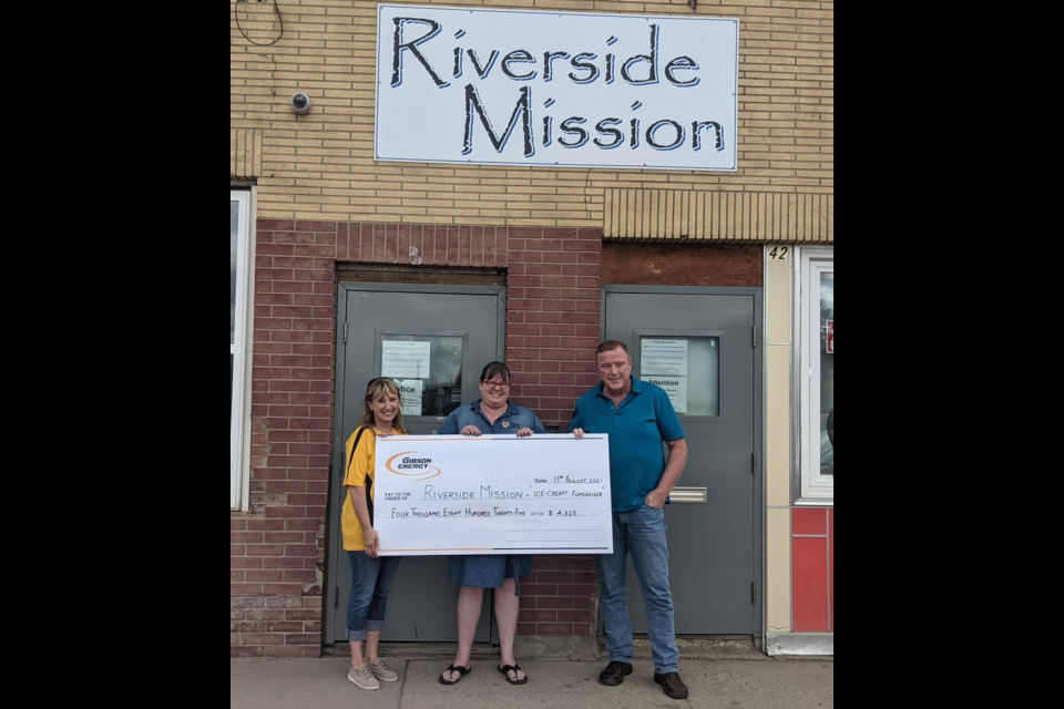 Bev Hissett (left) and Clayton Leavitt (right) with Gibson Energy in Moose Jaw give a cheque for $4,825 to Riverside Mission's Rachel Mullens. Photo courtesy Gibson Energy