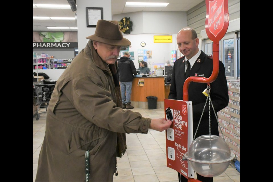Mayor Clive Tolley (left) uses his credit card to make the first (electronic) donation of the Salvation Army's 2022 kettle campaign, while Lt. Lester Ward looks on. Photo by Jason G. Antonio
