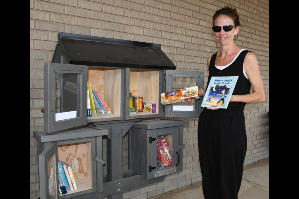 Wanda Peakman with the Moose Jaw Family Resource Centre shows some of the reading materials and food items that the library box outside the centre contains. Photo by Jason G. Antonio 