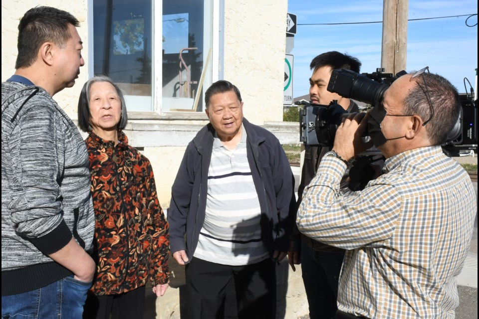 Businessman Gale Chow (centre) along with his son Kyle (left) and wife Myrna, speaks with director Weiyu Su while a cameraman records the interaction, in October 2021. Photo by Jason G. Antonio 
