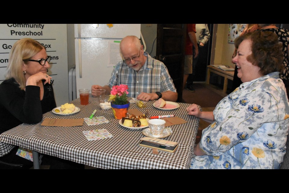 Jeannette Cole, board chair, Brad Leidal, board member, and Tricia Leidal enjoy the come-and-go tea. Photo by Jason G. Antonio