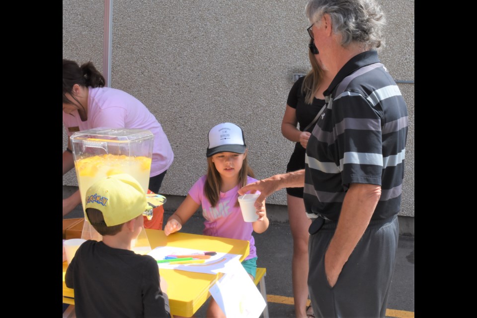 Siblings Asher and Raeya Harkness serve up lemonade to Terry Malloy during the CIBC Run for the Cure lunch fundraiser on Aug. 16. Photo by Jason G. Antonio