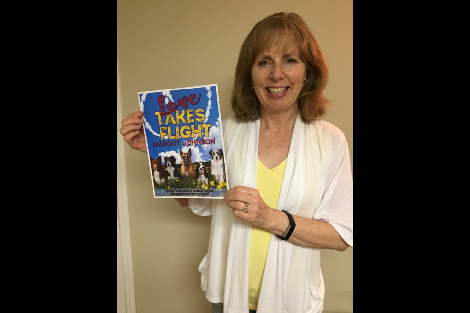 Margot Johnson holds up the cover of her debut novel, Love Takes Flight, available July 10. (supplied)