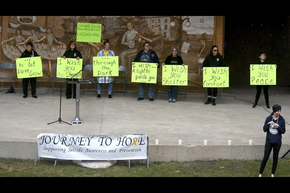 Members of the Journey to Hope committee hold up signs with inspirational messages during the song I Wish You Peace by The Eagles.