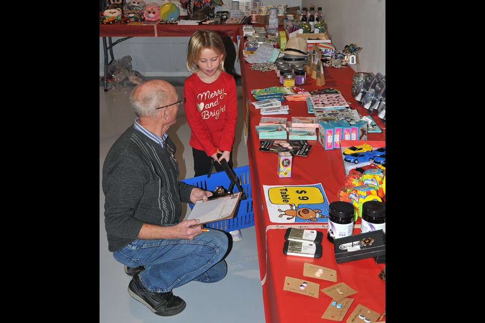 Winter checks out some of the items for sale with some help from WDM volunteer Lloyd. Randy Palmer photograph