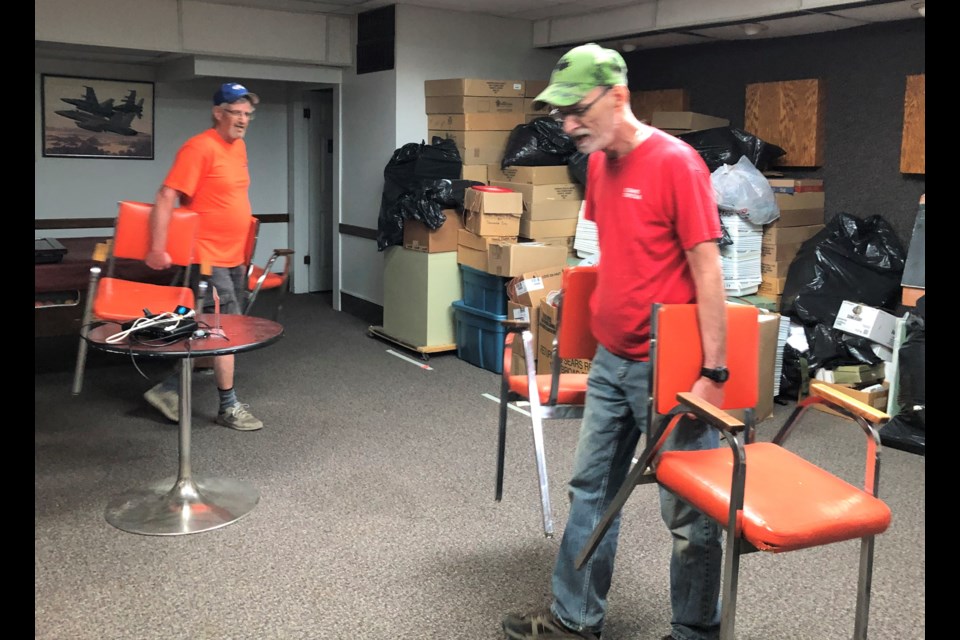 Legion members Dave Dryburgh and Rene LaChance remove broken furniture from the sports room as they help the organization downsize and reduce its possessions. Photo by Jason G. Antonio 