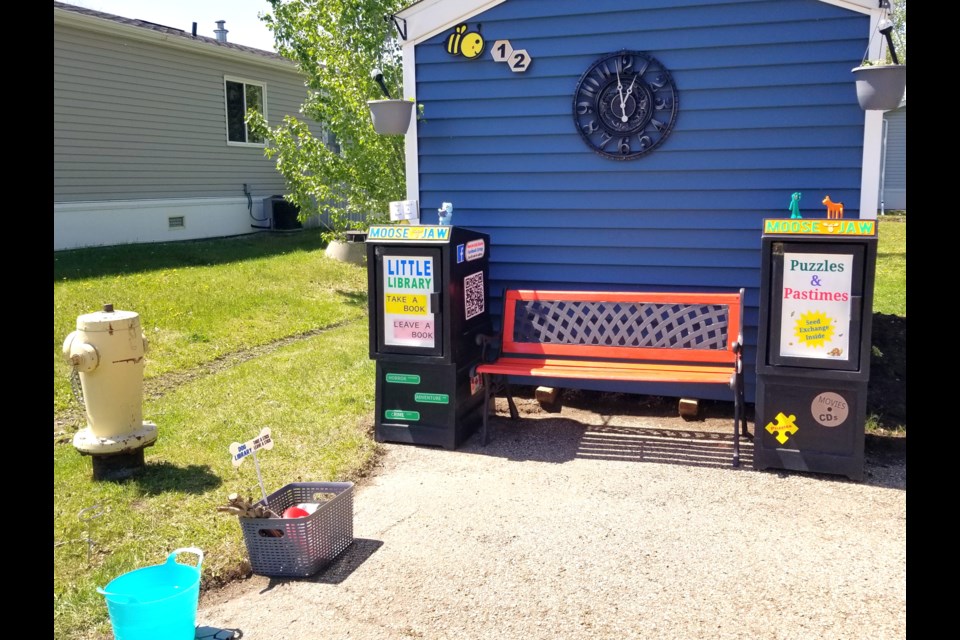 A view of Teresa and Delmar Davies’ Little Library hub at their home in B12 Prairie Oasis, which includes a book-sharing unit and a second “Puzzles & Pastimes” unit filled with games, crafts, and more.