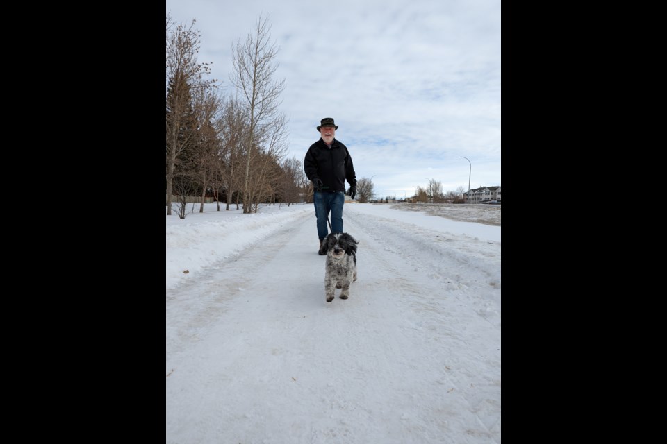 Marco leads Glenn Hagel on their daily walk along Thatcher Drive