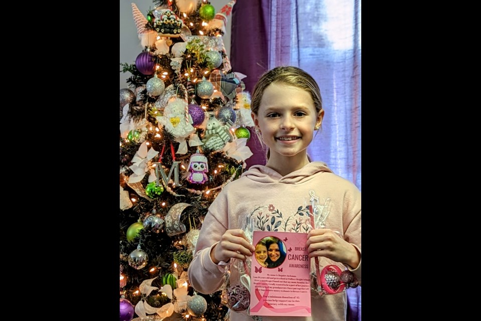 Maguire Jackman stands with several of her super-sparkly ornament bags next to her family's Christmas tree