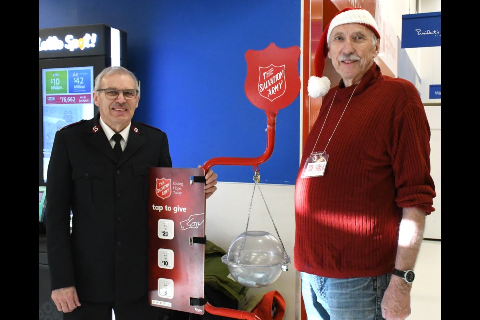 Maj. Clarence Ingram with the Salvation Army and volunteer Fred German help launch the annual Kettle Campaign, on Nov. 24 at Superstore. Photo by Jason G. Antonio