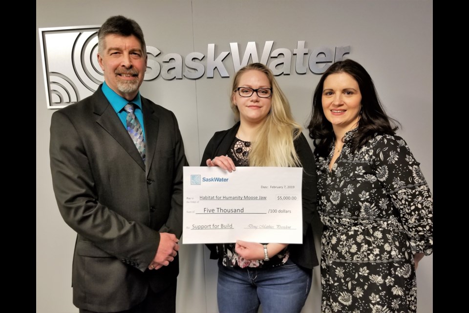 President of SaskWater Doug Matthies (left) and manager of corporate communications at SaskWater, Courtney Mihalicz (right), present a check to Habitat for Humanity’s Heidi Tiller (centre). (Sasha-Gay Lobban photo.)
