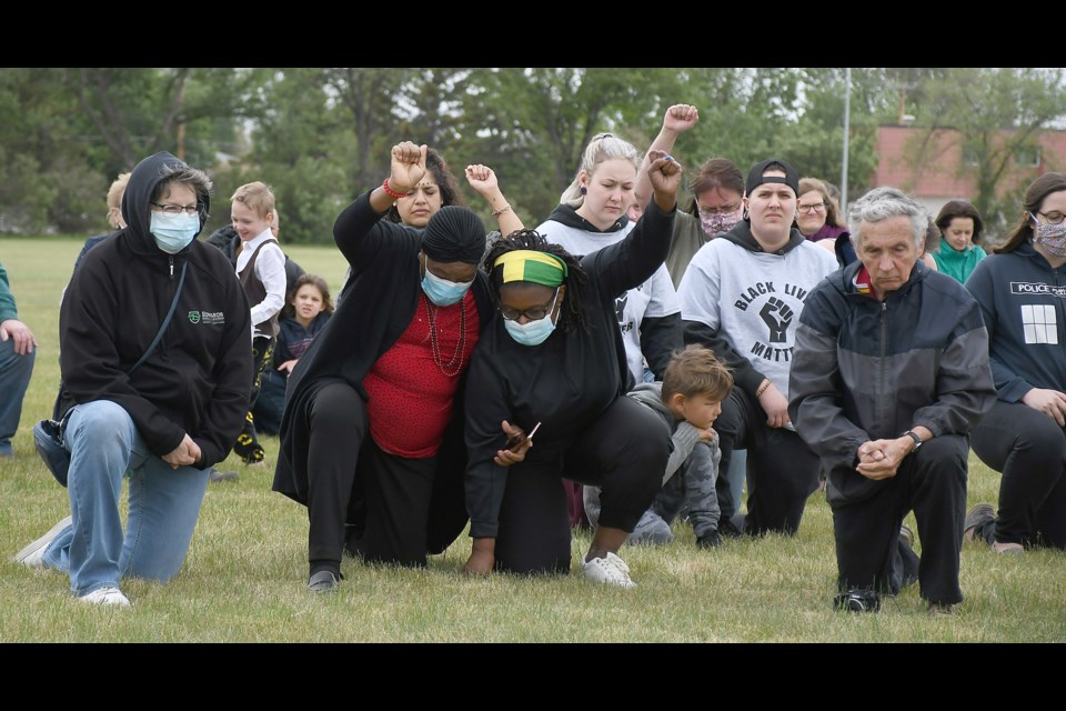 Supporters of the Solidarity Rally take a knee at the end of the event.