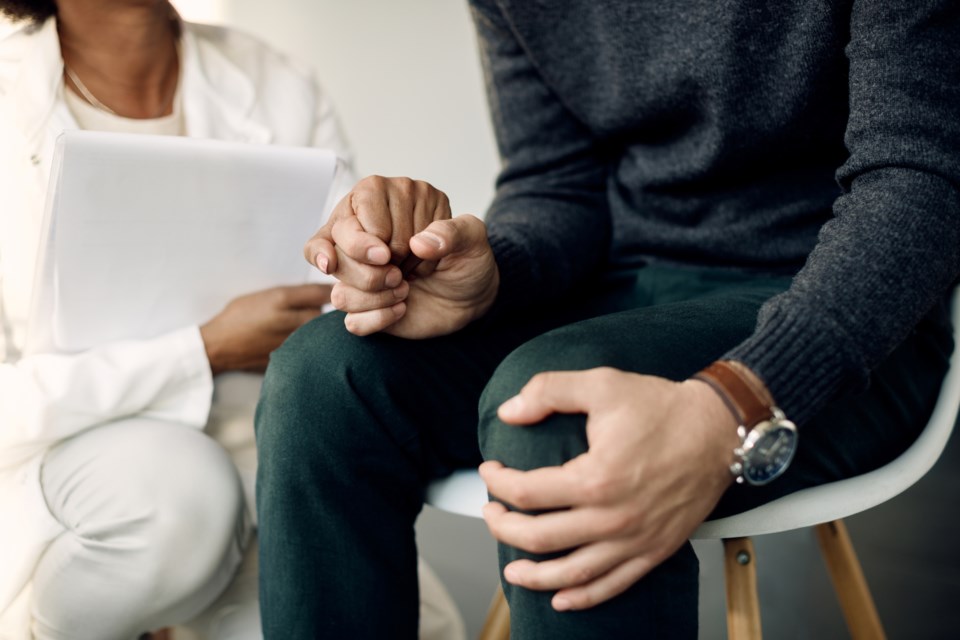 Supportive psychotherapist holding an anxious client's hand (Drazen Zigic - iStock - Getty Images Plus)