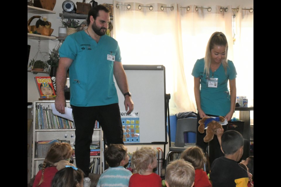 Nursing students Cole Hoffart and Kaleigh Yanke speak to students at the Southwest Day Care at the start of the teddy bear clinic. Photo by Jason G. Antonio