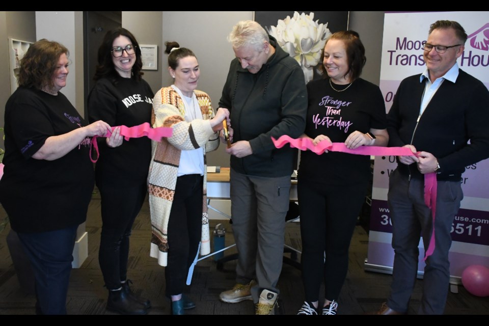 Jenn Angus, executive director (third from left) and Mayor Clive Tolley (third from right) cut a pink ribbon to officially open the downtown office. Also pictured are, from left, Michelle Welsh, Amber Finiak, Tammy McCleary and Tim Leipert. Photo by Jason G. Antonio