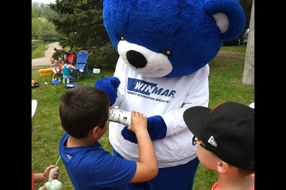 Willy Winmar signs a cast for a young visitor.