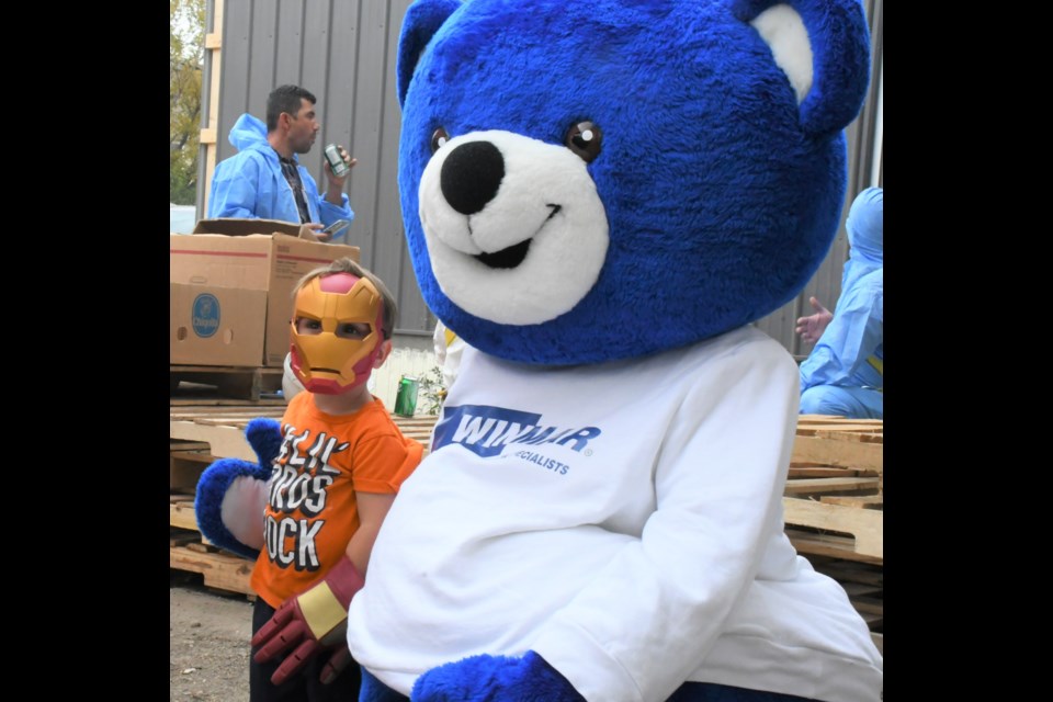 Jace (Ironman) Moore shakes a paw with Willy the Winmar Bear during the barbecue. Photo by Jason G. Antonio 
