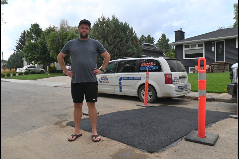 Aaron McGillvary stands in front of the repair in front of his Keith Street residence