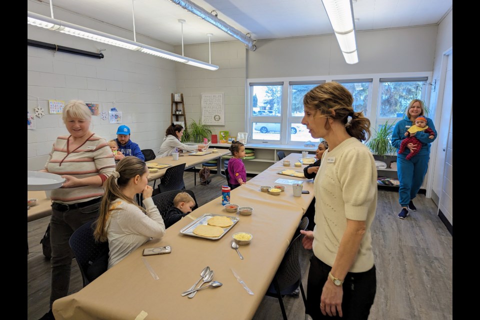 Facility staff chat with parents and children as they make pizzas for family literacy day at the Moose Jaw Early Years Family Resource Centre